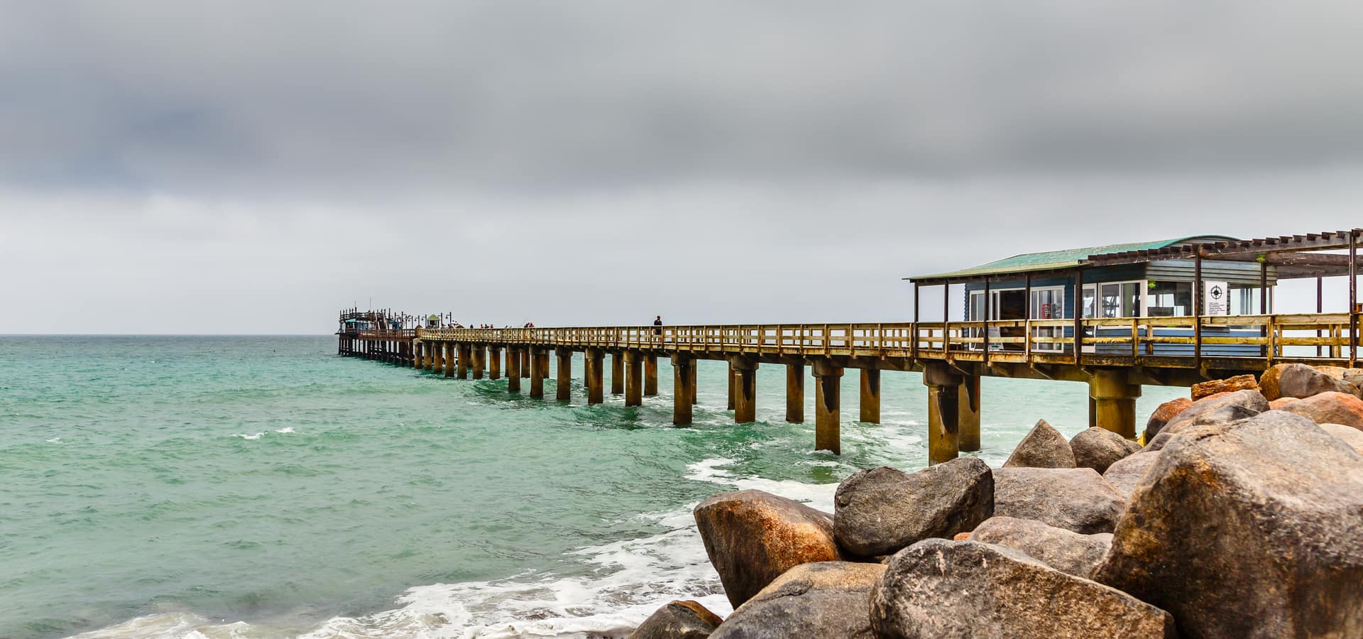 Rocky Swakopmund coastline with the long pier